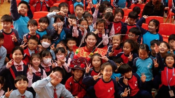 學生與川劇變臉表演者合影